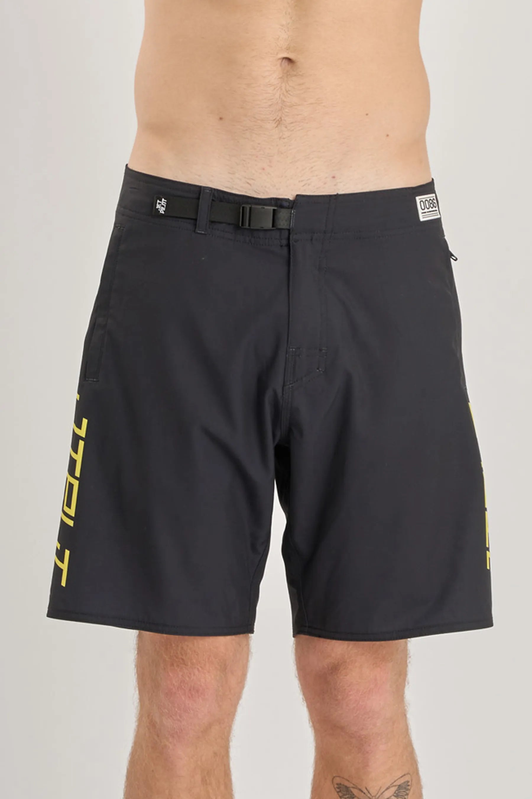 Black shorts with yellow branding on a grey background