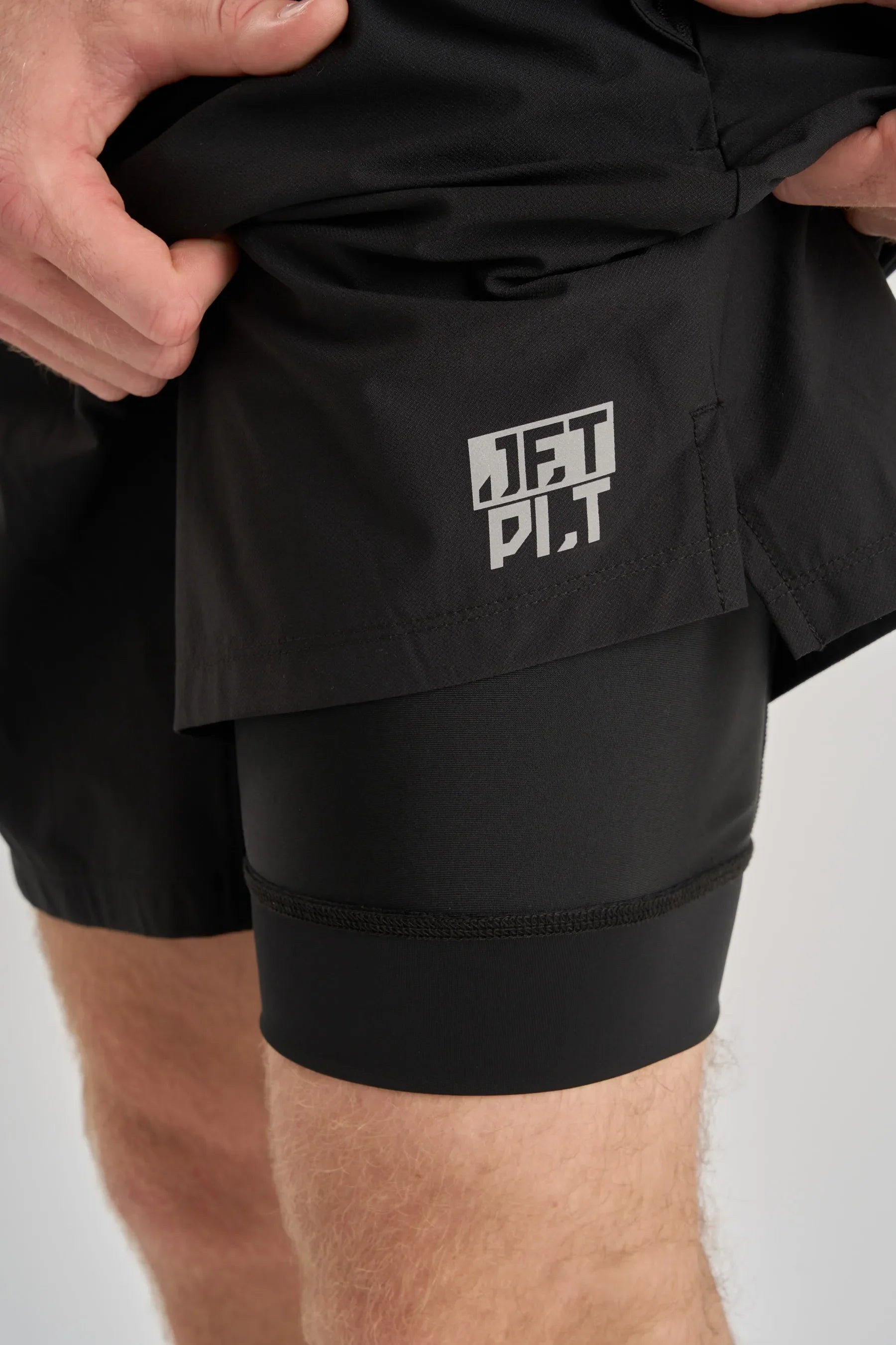 Black board shorts with a visible brand logo on a white background