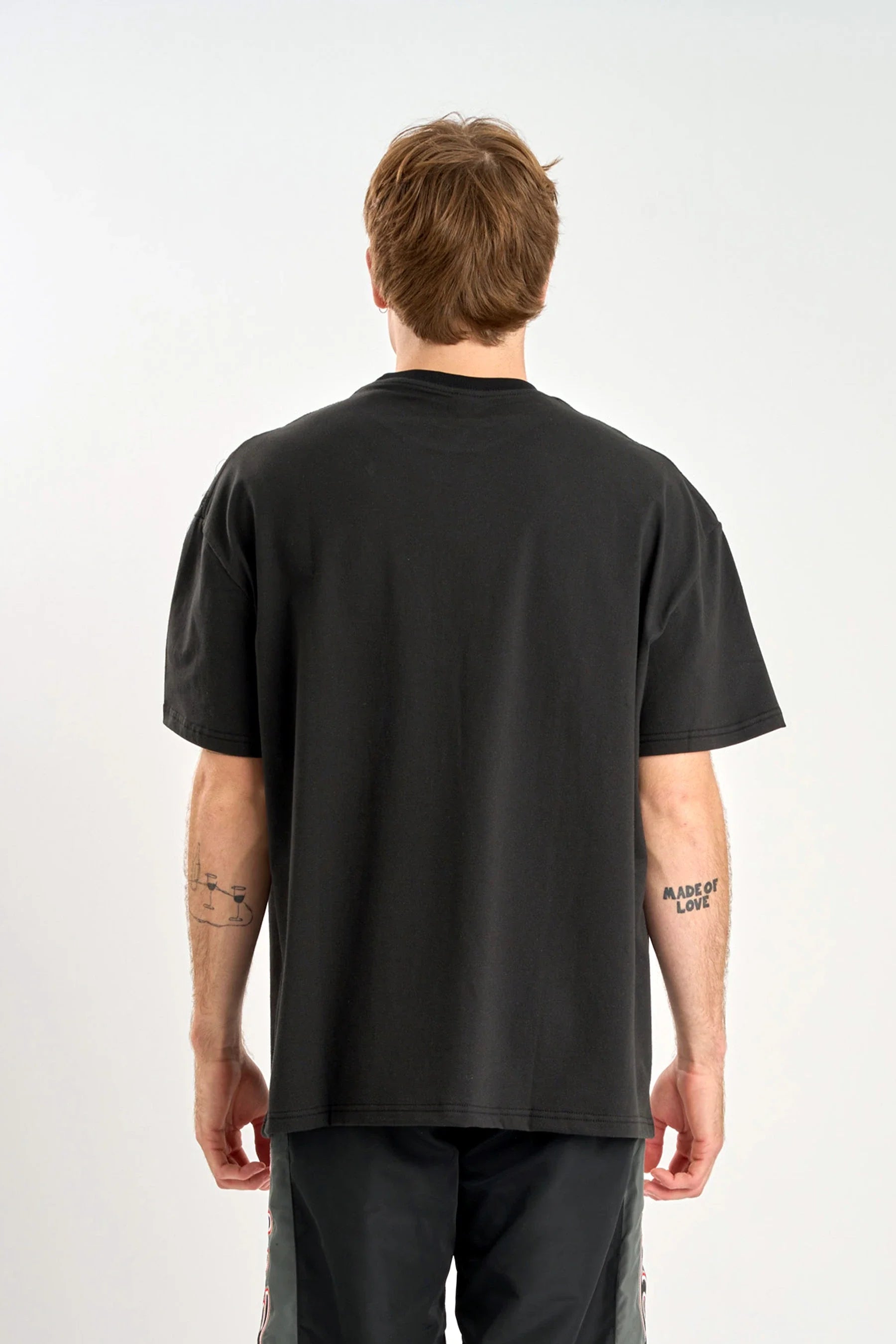 Back view of wearing a Jetpilot Moto Heavy Tee - Black on a white background