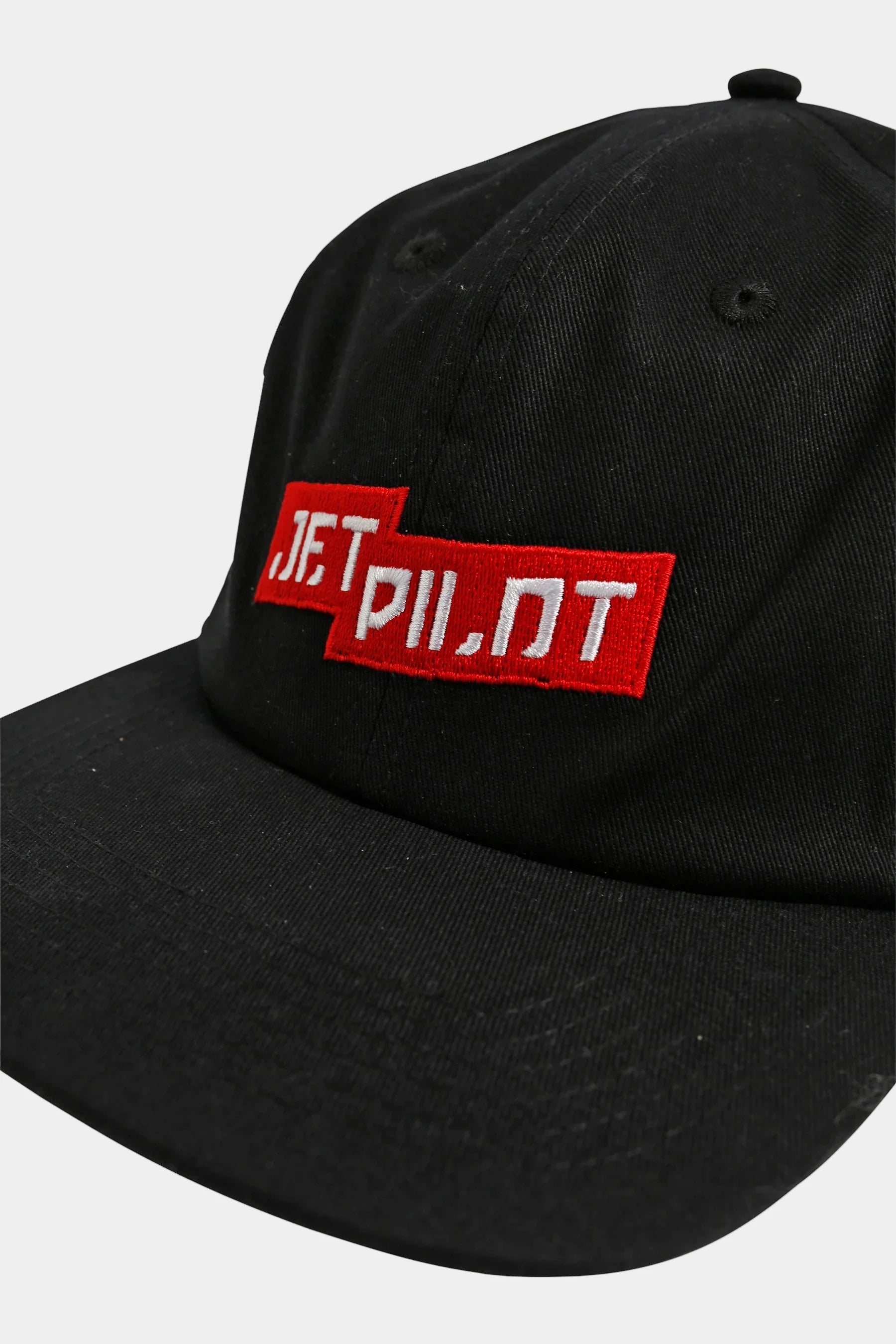 Black cap with red & white 'Jetpilot' text on a white background