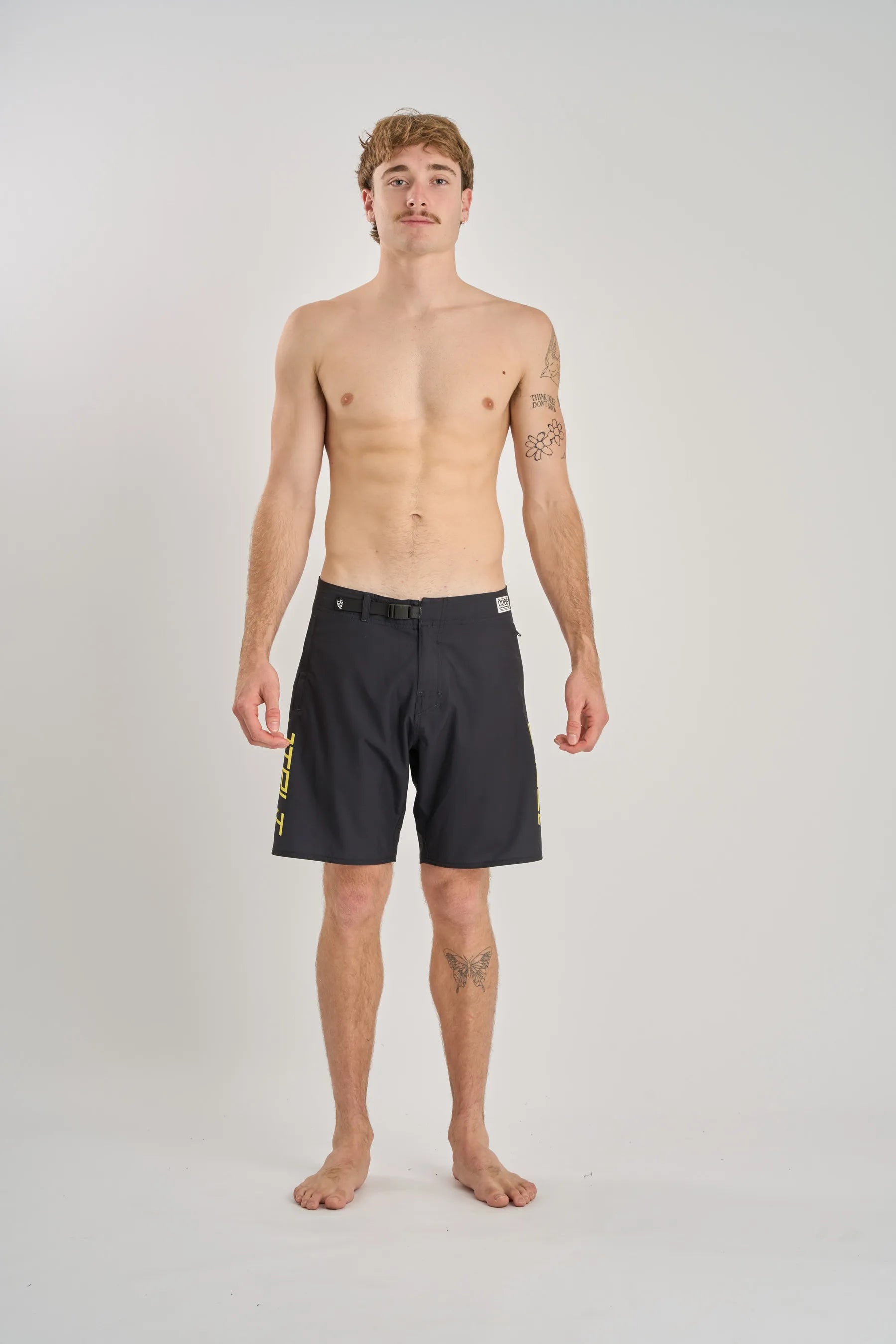 Man wearing black board shorts on a white background