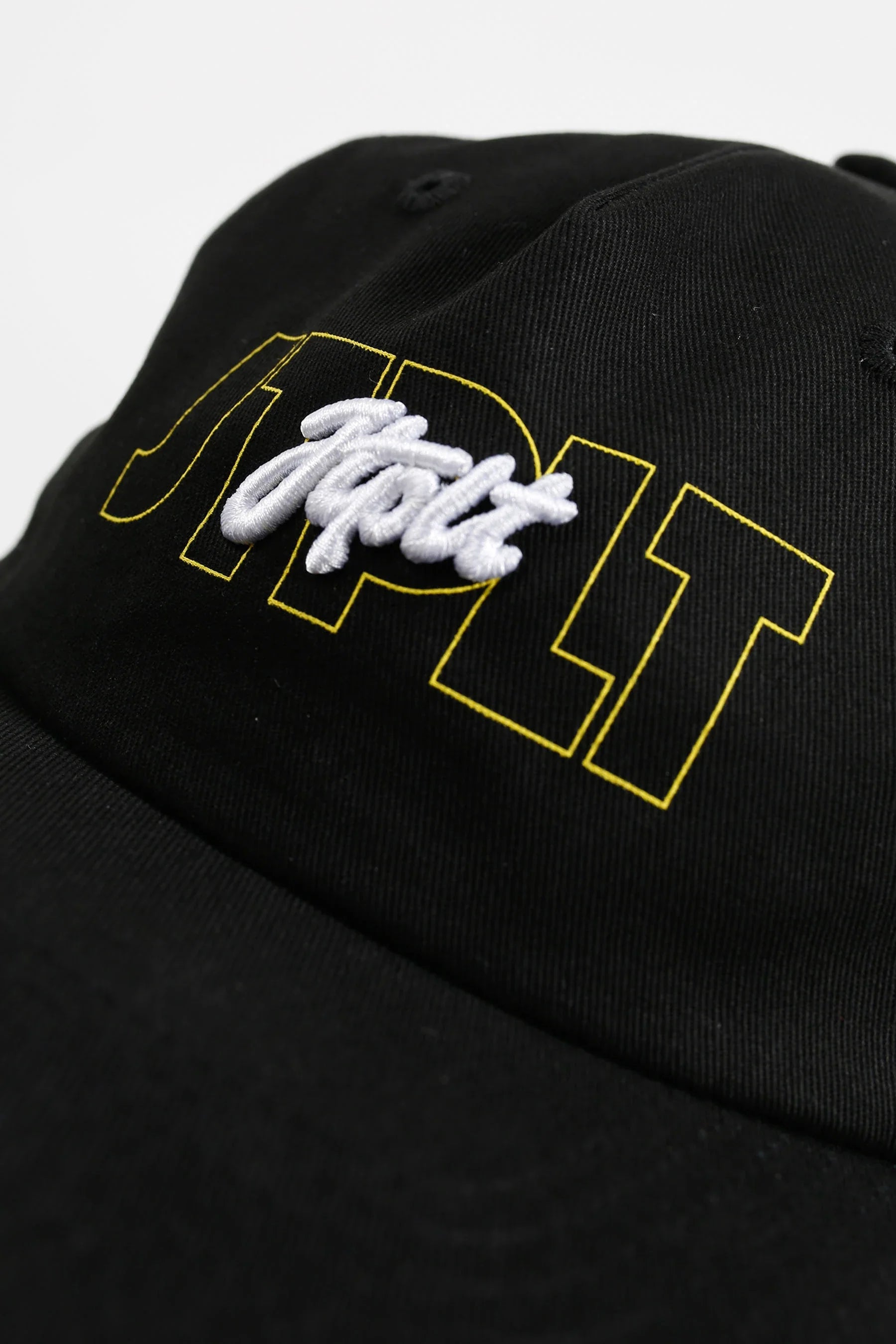 Black cap with white and yellow text on a light gray background