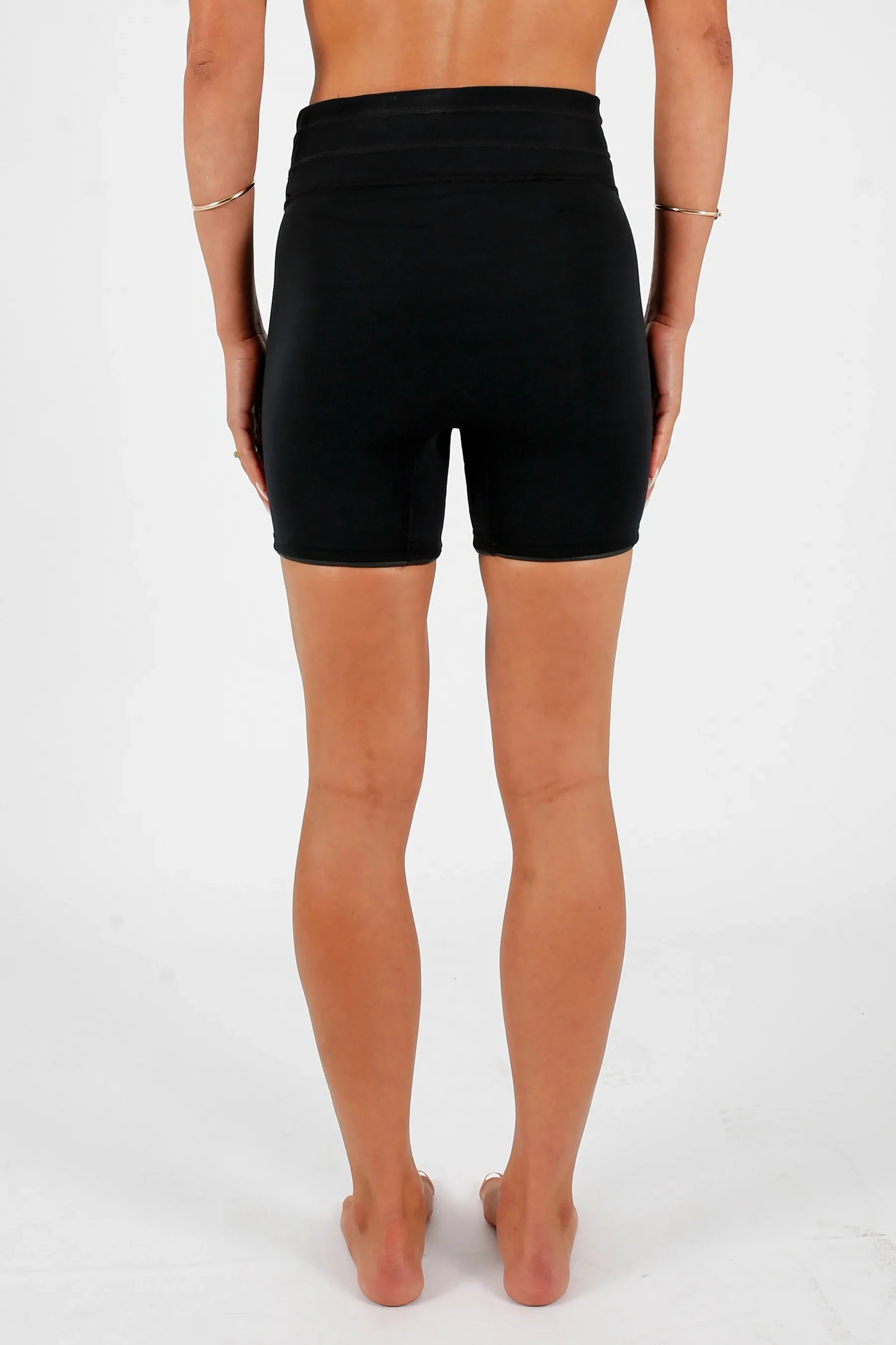 Person wearing Jetpilot Corp 5" High Waisted Neoprene Short - Black on a white background